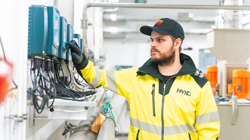Kuvassa huoltoasentaja keltainen työtakki päällä.